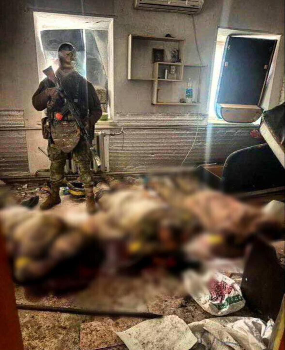 In this photo posted on Telegram on November 15, this Russian fighter poses in front of the bodies of three Ukrainian soldiers.