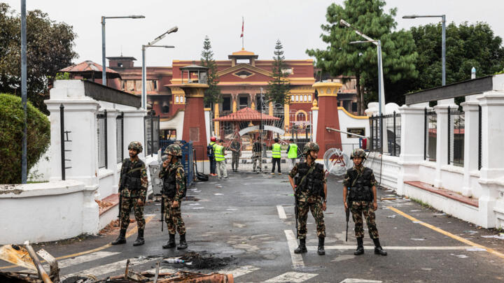 Army personnel stand near charred remains as they patrol along a street outside the torched President House in Kathmandu on September 10, 2025.