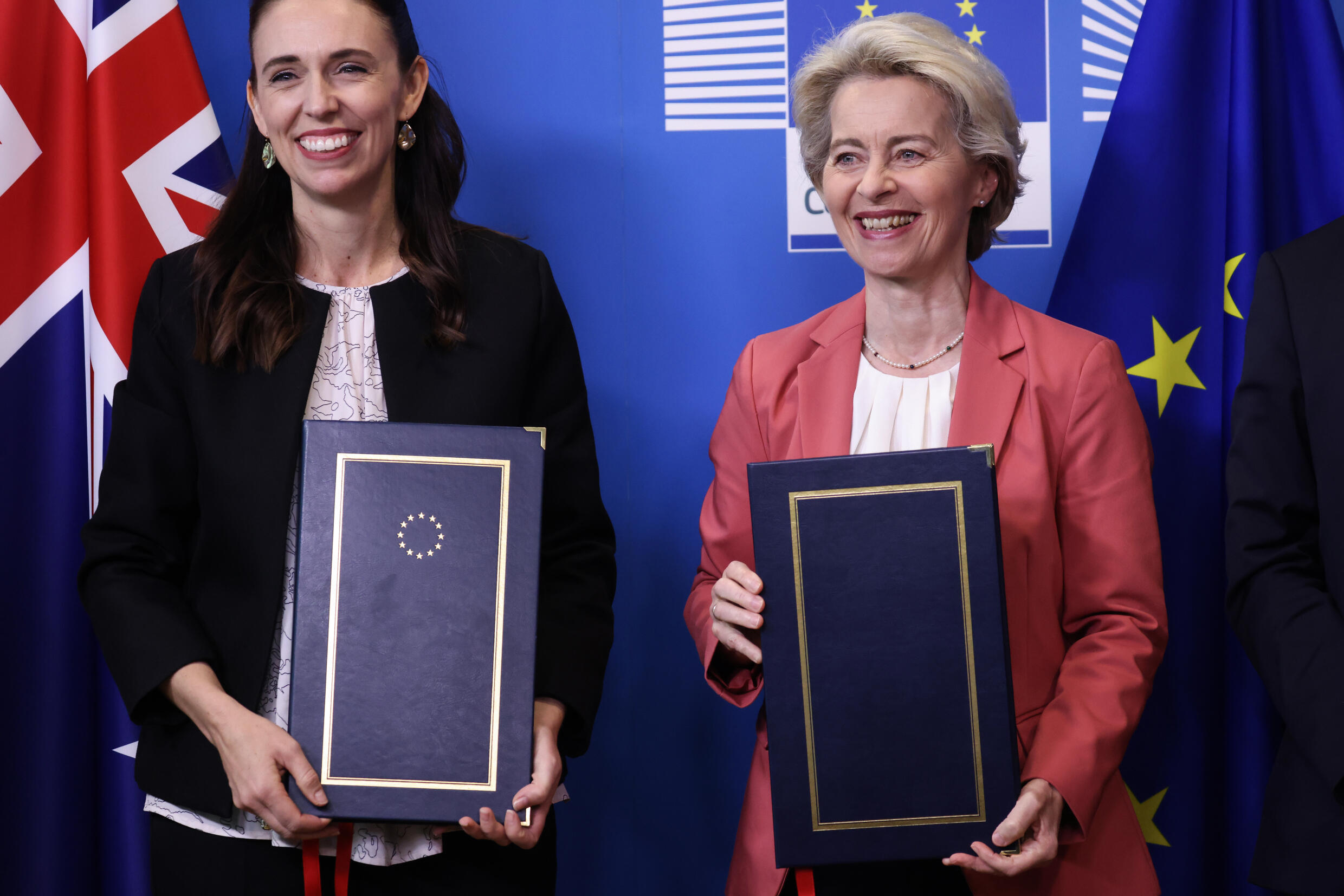 Jacinta Artern (left) and Ursula van der Leyn pose for a laugh with copies of the Free Trade Agreement between New Zealand and the European Union in Brussels on June 30, 2022.