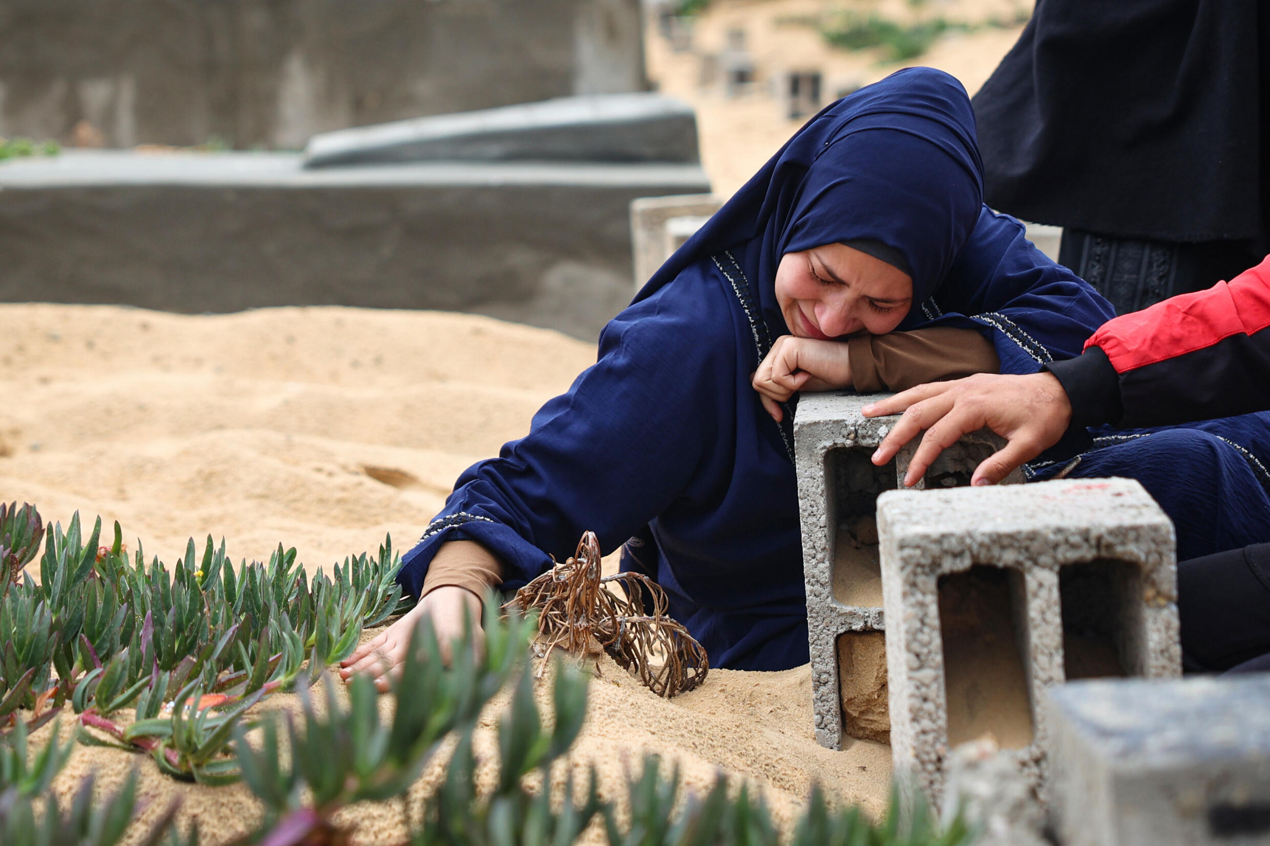 Une femme pleure sur la tombe d'un proche, dans un cimetière à Rafah, dans le sud de la bande de Gaza, le 10 avril 2024
