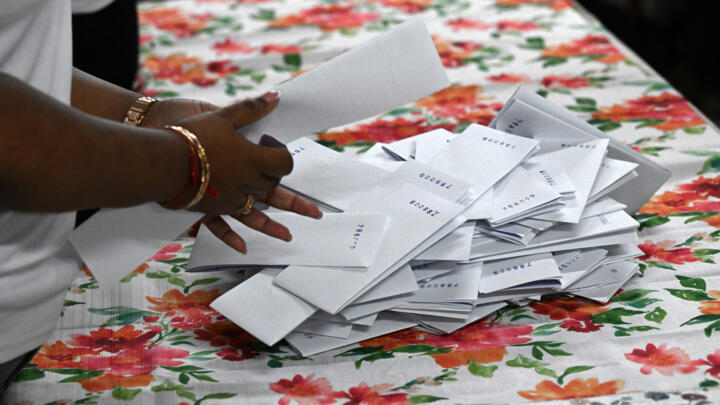 An election staffer counts votes after the closing of a polling station during the presidential election in Cornelia Ida, Guyana, on September 1, 2025.