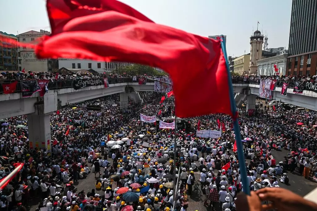 Una bandera ondea mientras los manifestantes protestan contra el golpe militar en Yangon, Myanmar, el 22 de febrero de 2021.