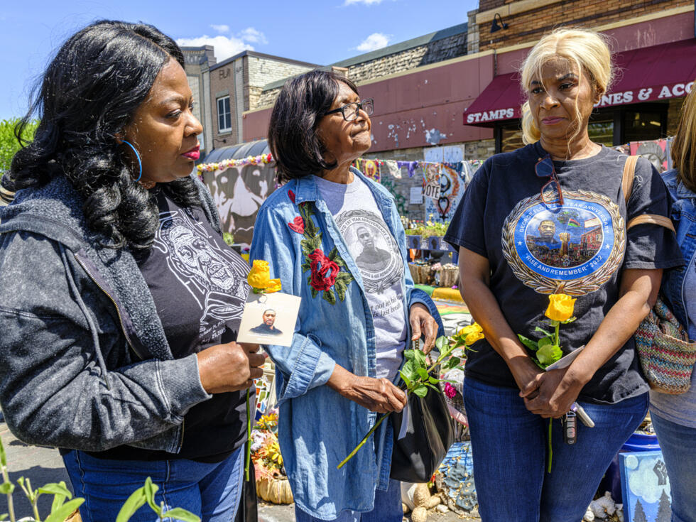 Angela Harrelson (d), tante de George Floyd, assiste à une cérémonie d'hommage en compagnie de Laura Stevens (c) et Mahalia Jones, le 23 mai 2025 à Minneapolis, dans le Minnesota