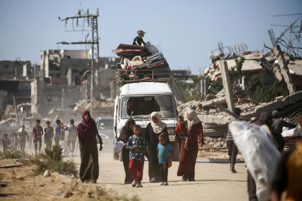 Un groupe de déplacés palestiniens sur le chemin du retour, le 14 octobre 2025, dans la zone d'al-Zahra, dans la bande de Gaza.