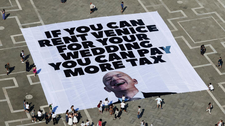 A large banner against Amazon founder Jeff Bezos lies on the ground in St. Mark's Square in Venice, Italy, on June 23, 2025.