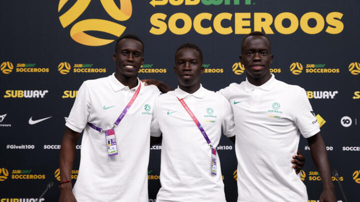From left to right: Australia's Thomas Deng, Garang Kuol and Awer Mabil pose for a photo after their press conference in Doha.