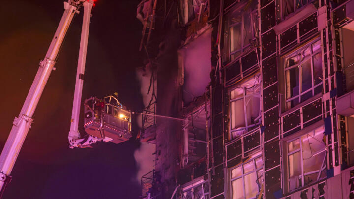 Emergency services personnel work to extinguish a fire following a Russian attack in Kyiv, Ukraine.