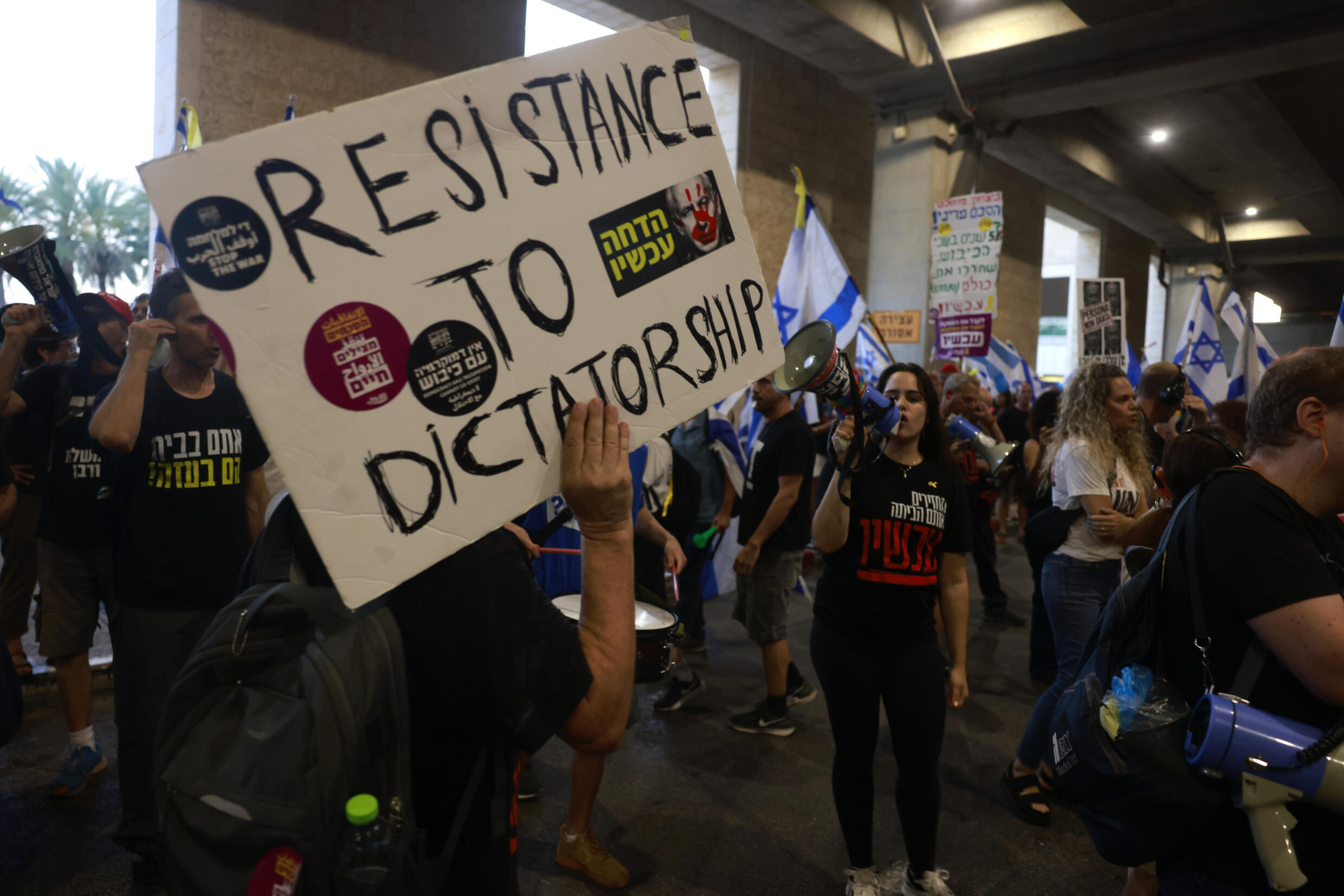 Des manifestants protestent à l'aéroport Ben Gourion de Tel-Aviv, avant le départ pour Washington du Premier ministre Benjamin Netanyahu, le 21 juillet 2024