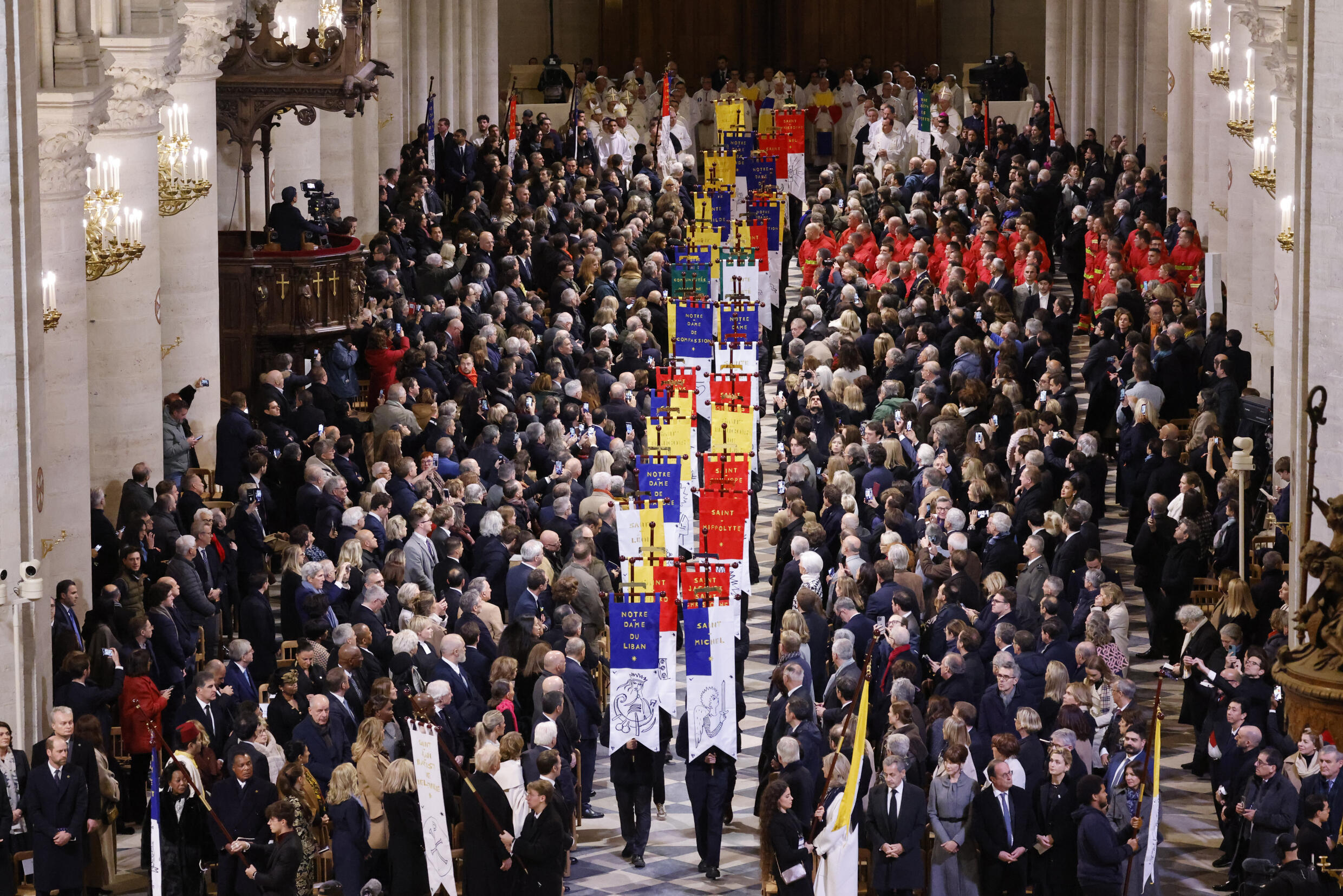 Les invités assistent au défilé des bannières d'église lors de la cérémonie de réouverture de la cathédrale Notre-Dame, le 7 décembre 2024 à Paris