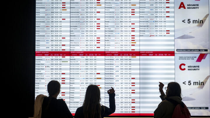 Passengers look at a departures board in Montreal, Canada, during the Air Canada strike.