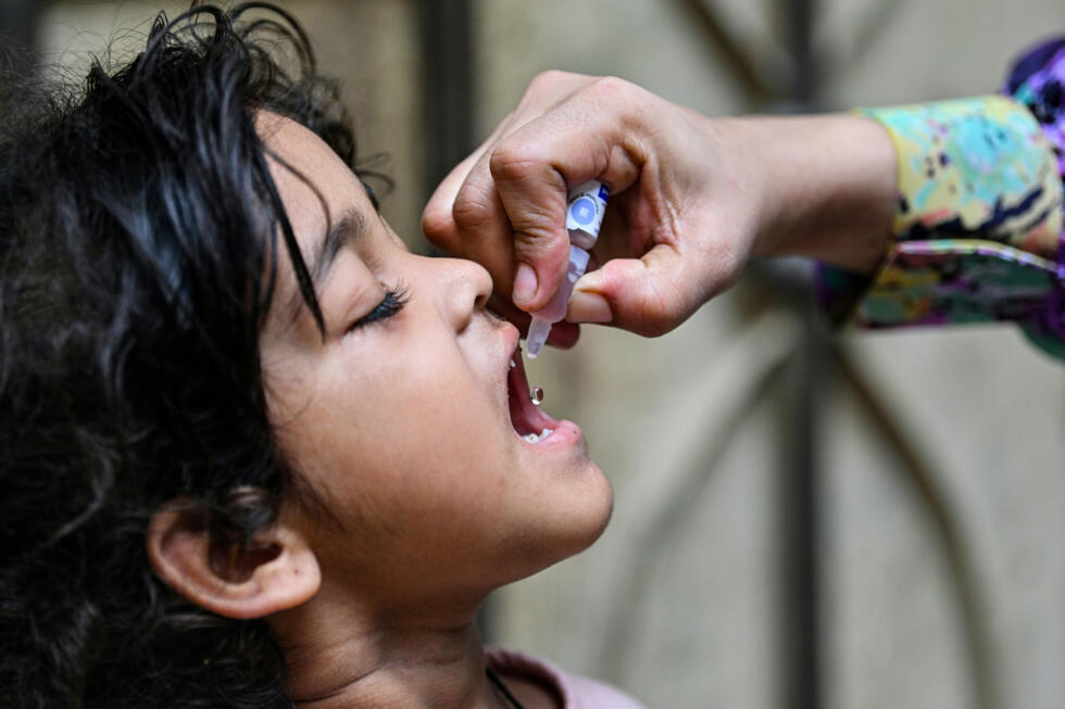 Un agent de santé administre des gouttes anti-polio à un enfant pour le vacciner à Karachi, au Pakistan, le 26 mai 2025.
