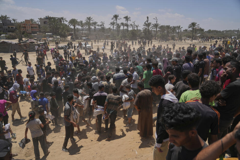 Palestinos se apresuran a recoger ayuda humanitaria lanzada en paracaídas sobre Zawaida, en el centro de la Franja de Gaza, el lunes 4 de agosto de 2025.