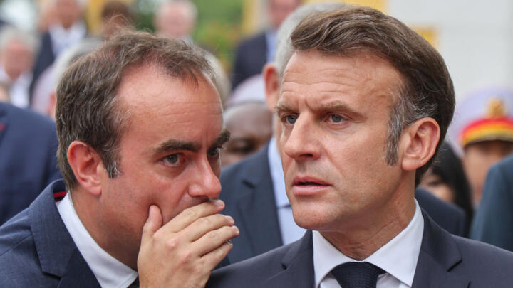 Lecornu whispers to Macron after taking part in a wreath-laying ceremony in this file photo from May 26, 2025 . 
