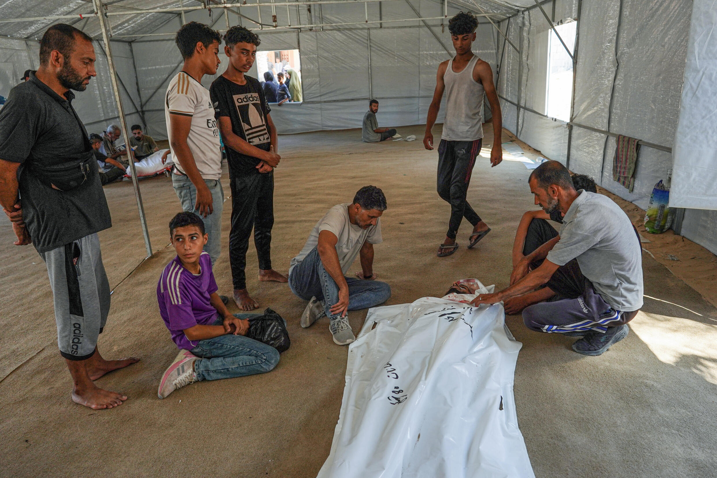 Des Palestiniens pleurent devant le corps d'un proche tué lors de bombardements israéliens, à l'hôpital Nasser de Khan Younès, dans le sud de la bande de Gaza, le 16 juillet 2024