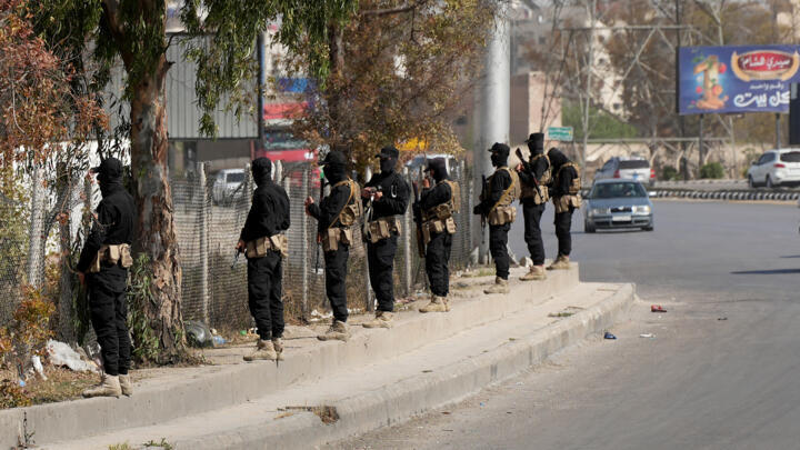 Security forces of Syria's new Islamist government stand guard on the road leading to the airport in the Damascus suburb of Jaramana on April 29, 2025.