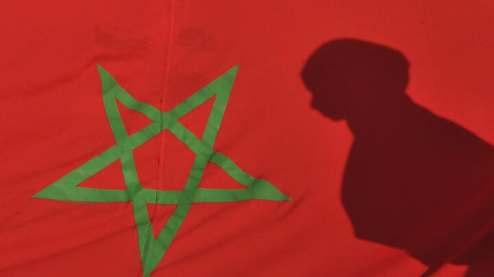 The shadow of a young woman is seen on a Moroccan flag during a demonstration in Rabat on November 6, 2010.