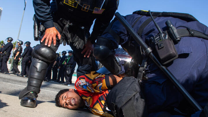 California Highway Patrol officers arrest a demonstrator in the overpass of the 101 Freeway as protests continue in response to federal immigration operations in Los Angeles on June 10, 2025.