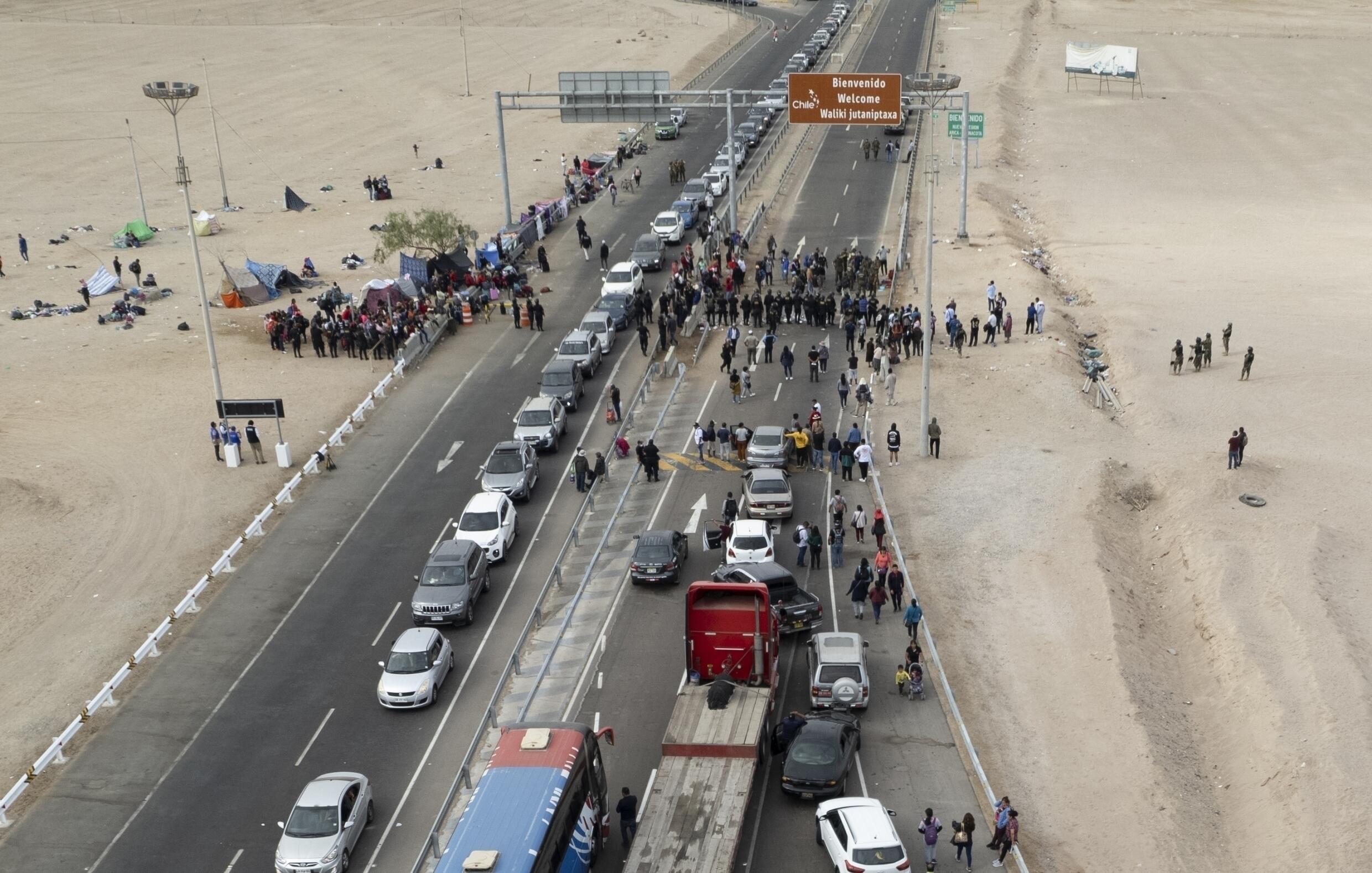 Migrantes venezolanos varados bloquean el paso fronterizo en Tacna, Perú, después de que las autoridades chilenas los devolvieran a Perú, donde las autoridades no les permiten viajar más al interior del país, 29 de abril de 2023.