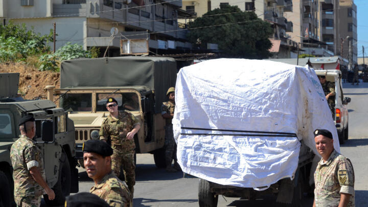 Lebanese army soldiers stand guard as a truck loaded with weapons leaves the Palestinian refugee camp of Beddawi, near the northern city of Tripoli on September 13, 2025. 