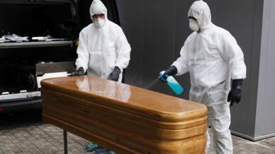 Imagen de archivo de trabajadores de un tanatorio sacando del hospital un ataúd para proceder a su desinfección antes de trasladarlo al cementerio.