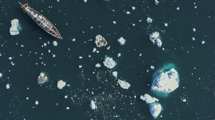A ship navigates between icebergs near Greenland in the Arctic, on August 15, 2023.
