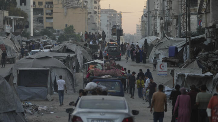 Displaced Palestinians fleeing northern Gaza Strip move with their belongings on a street in Gaza City, August 29, 2025. 
