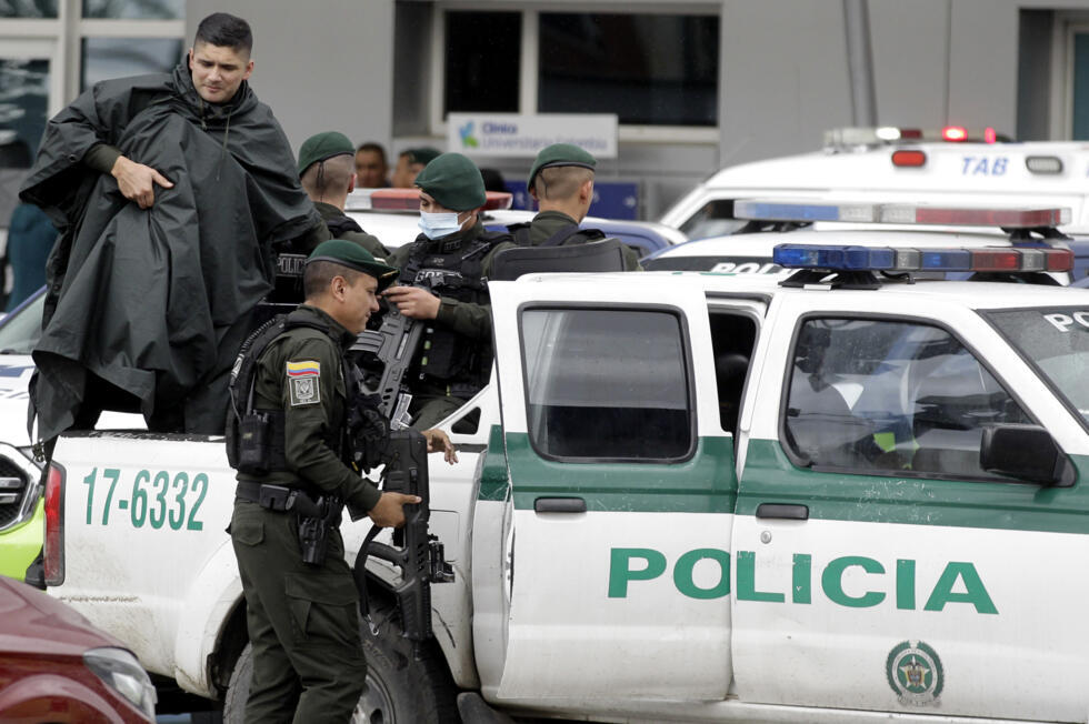 Des policiers escortent le jeune tueur à gages qui a tiré sur le candidat à la présidence colombienne Miguel Uribe, quittant la clinique universitaire de Colombie à Bogota, le 10 juin 2025