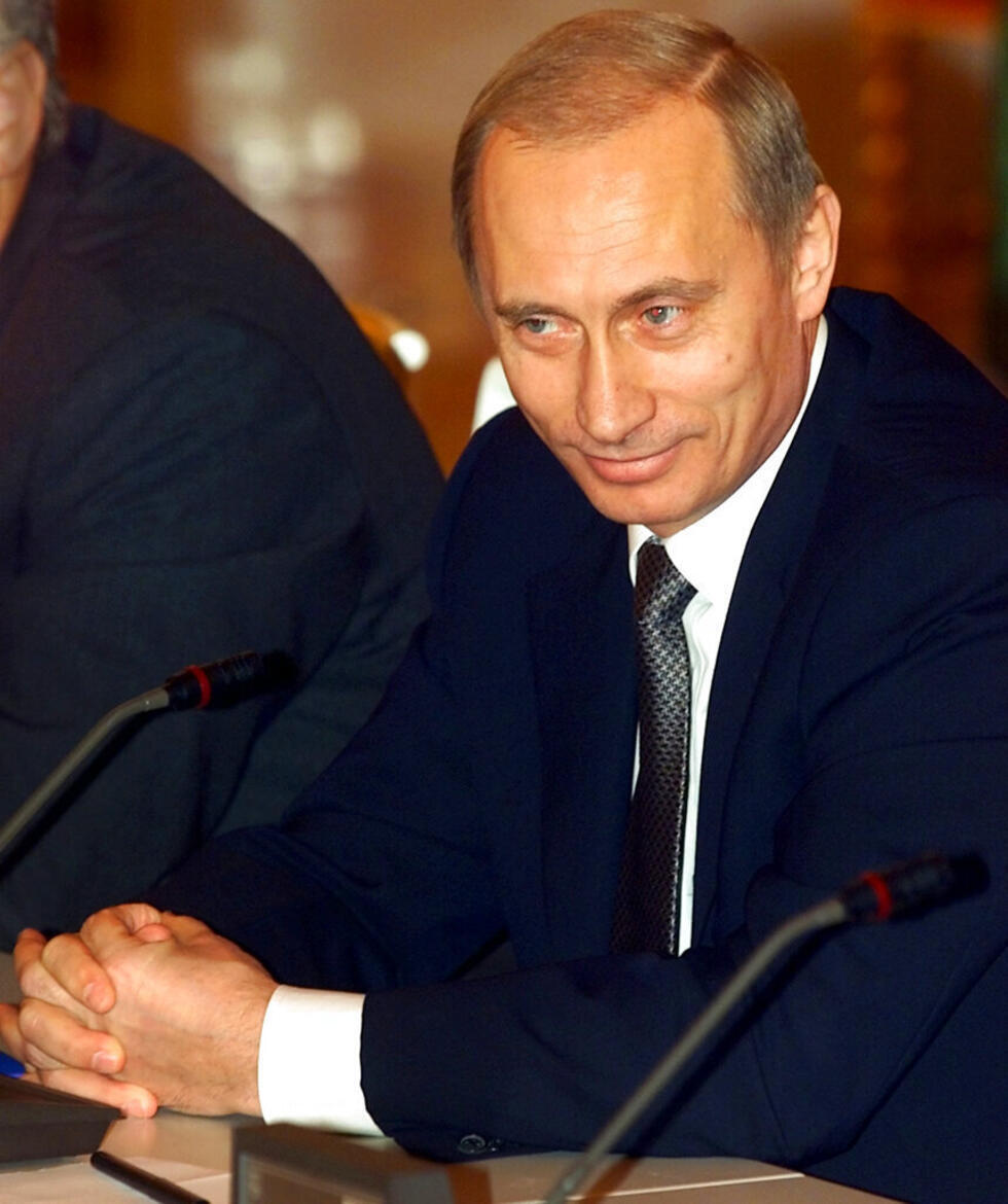 El presidente Vladimir Putin sonríe mientras escucha una pregunta en una rueda de prensa tras la cumbre del aniversario de la CEI en el Kremlin de Moscú, en esta foto del 30 de noviembre de 2001.