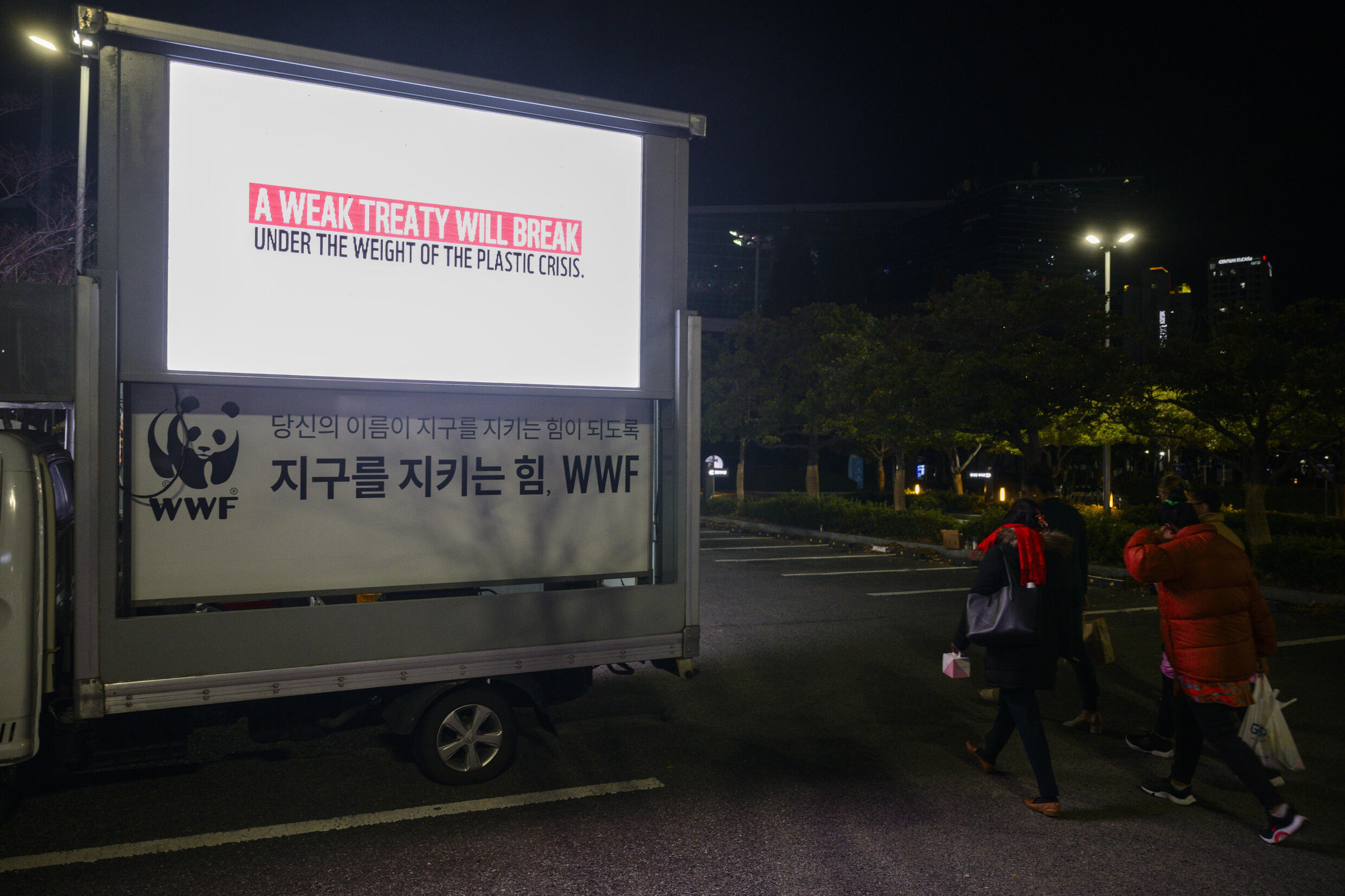 Un panneau publicitaire met un garde contre un traité contre la pollution plastique "faible", le 30 novembre 2024 devant le palais des congrès de Busan, en Corée du Sud.
