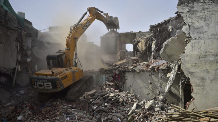 A bulldozer demolishes Javed Mohammad's house in Allahabad, India on June 12, 2022.