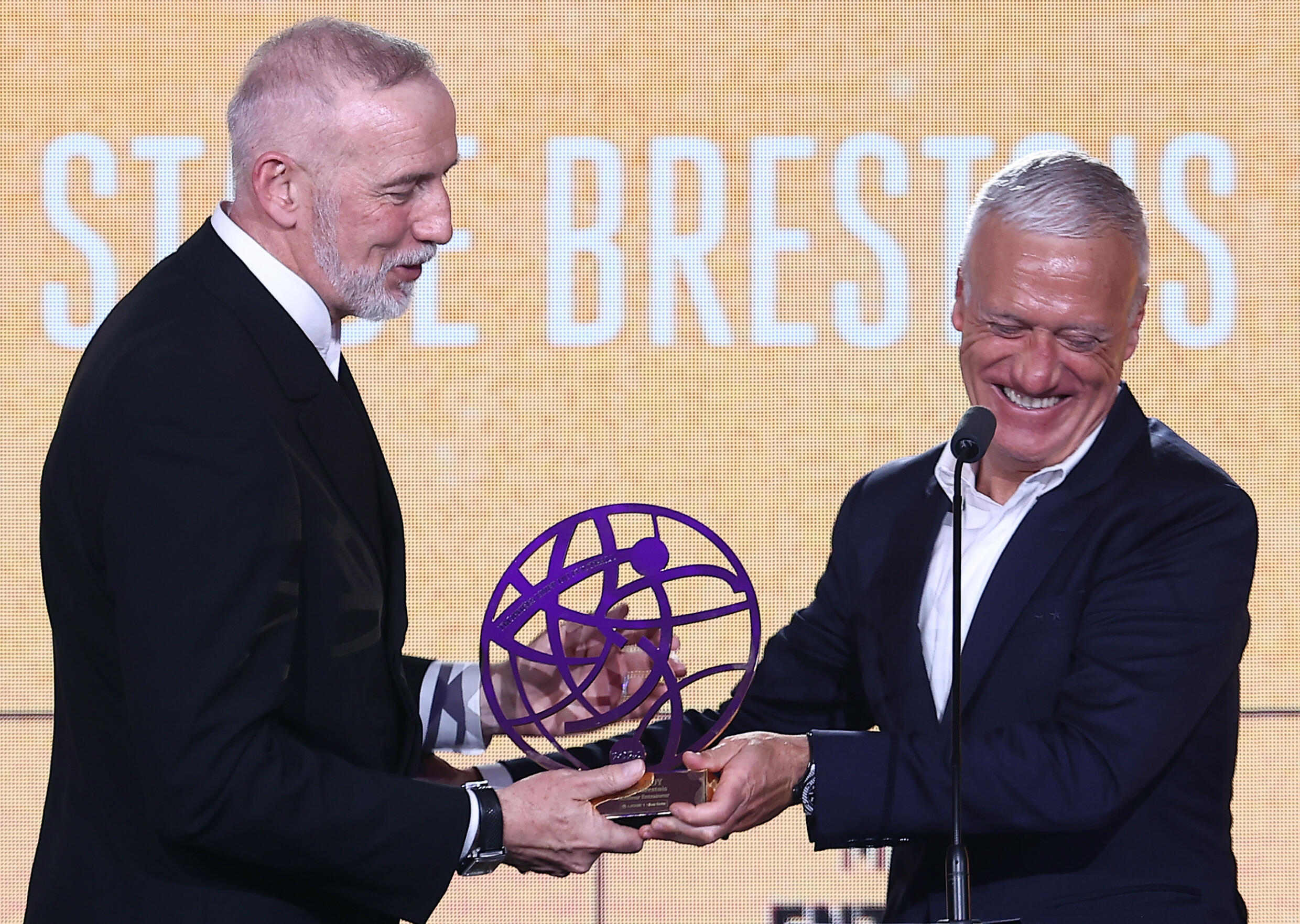 L'entraîneur de Brest Eric Roy reçoit le trophée de meilleur entraîneur de Ligue de la saison des mains du sélectionneur des Bleus Didier Deschamps le 13 mai 2024 à Paris