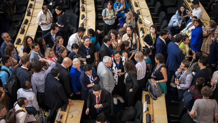 Delegates speak together after talks on a global treaty on combating plastic pollution were extended an extra day, late on August 14, 2025 in Geneva.