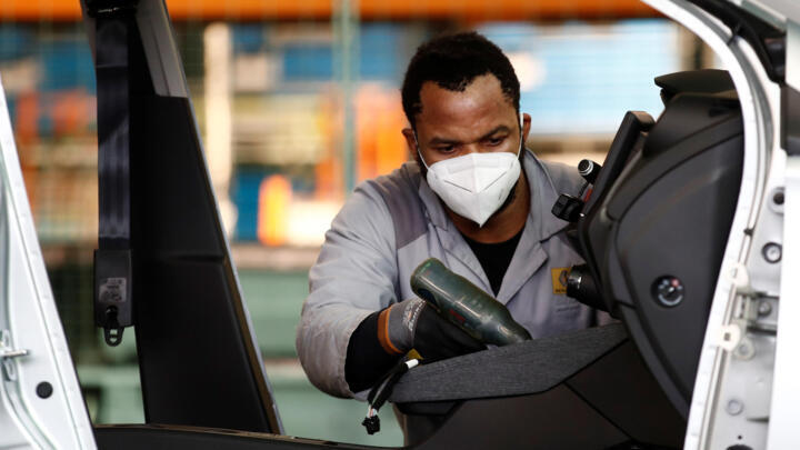 An employee works on the automobile assembly line of Renault ZOE cars at the Renault automobile factory in Flins, France, May 6, 2020.