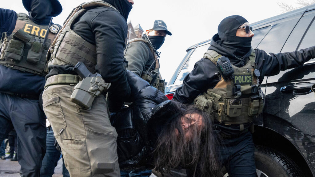 Una mujer detenida es detenida por agentes federales después de ser sacada de su vehículo en una redada de inmigración, que condujo a la detención de dos jóvenes hispanos y varios observadores, días después de que un agente de ICE disparara fatalmente a Renee Nicole Good, en Minneapolis, (EE. UU.), el 13 de enero de 2026.