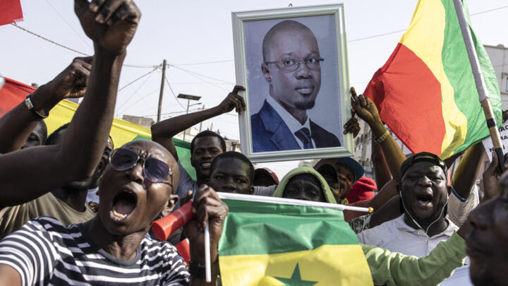 Opposition supporters sing and dance during a meeting two days before the trial of one of the leaders, Ousmane Sonko, in Dakar on March 14, 2023. 