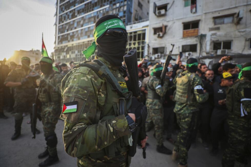 Des combattants des Brigades Qassam, la branche armée du Hamas, contrôlent la foule tandis que la Croix-Rouge rassemble les otages israéliens qui doivent être libérés dans le cadre d'un accord de cess