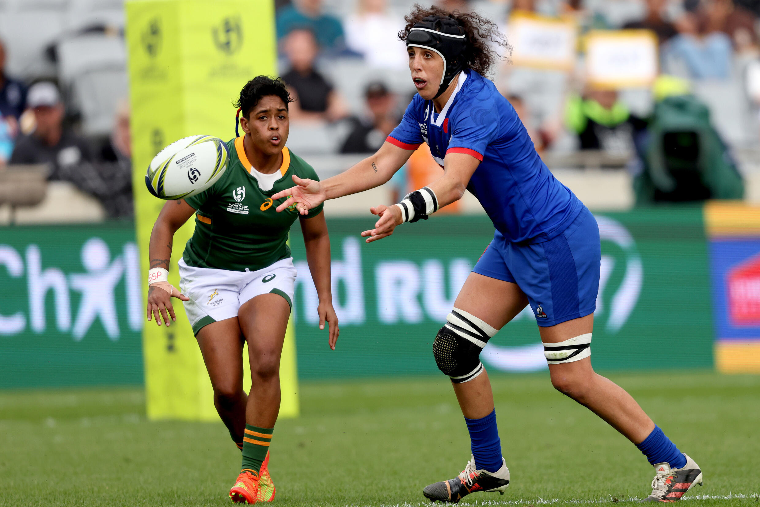 France's Céline Ferrer (right) passes the ball during the Women's Rugby World Cup Group C match between South Africa and France at Eden Park in Auckland on October 8, 2022