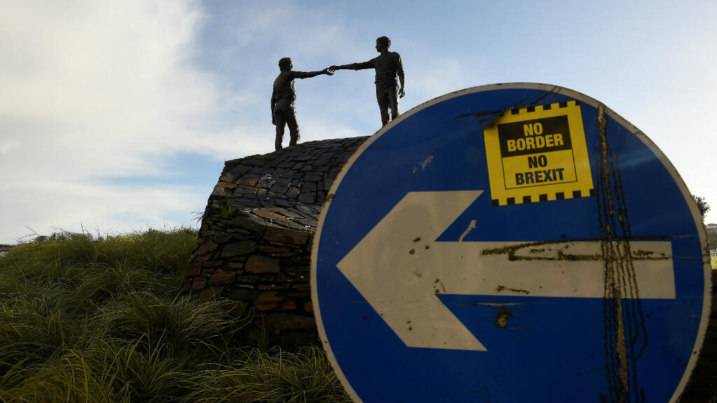 Se ve una etiqueta adhesiva 'No Border, No Brexit ' en una señal de tráfico frente a la estatua de la Paz titulada 'Hands Across the Divide' en Londonderry, Irlanda del Norte, el 22 de enero de 2019.