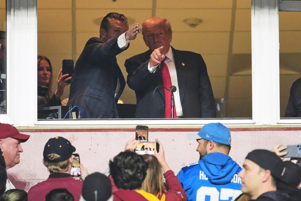 El secretario de Defensa Pete Hegseth y el presidente Donald Trump conversan durante un partido de la NFL. Maryland, 9 de noviembre de 2025. Venezuela ahora denuncia las acciones de ambos en el Caribe como "ejecuciones extrajudiciales".