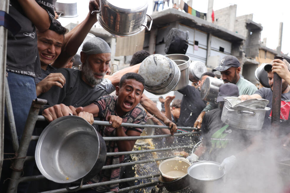 Des Palestiniens se pressent à une distribution de nourriture à Beit Lahia, dans le nord de la bande de Gaza, désormais menacée de "famine de masse" selon pluieurs ONG, le 15 mai 2025