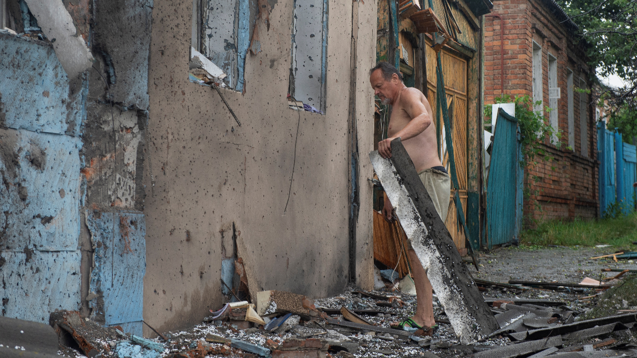 Un hombre retira los escombros de su casa dañada por un ataque militar ruso, mientras continúa el ataque de Rusia sobre Ucrania, en Jarkiv, Ucrania el 11 de julio de 2022.