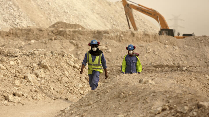 In this file photo taken during a government organized media tour, workers walk back to the Al-Wakra Stadium worksite being built for the 2022 World Cup, in Doha, Qatar. 