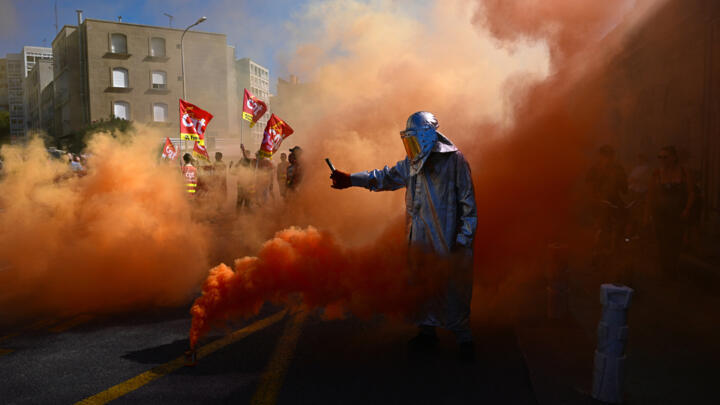 A protester lights flares in Marseille on September 18, 2025, during a day of nationwide strikes called by unions over a proposed national budget that critics say is too austere.