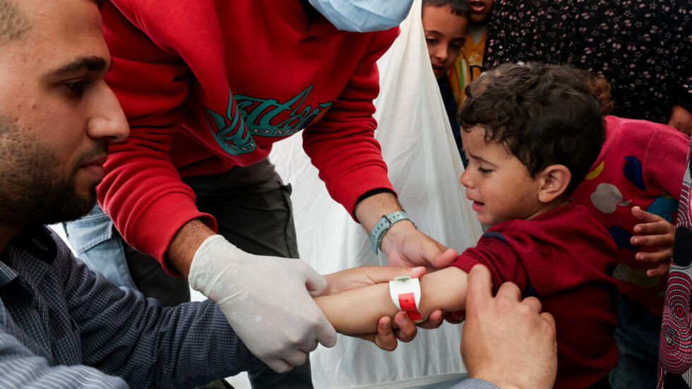 A Palestinian boy has his arm measured for malnutrition at a medical tent in Rafah, in the southern Gaza Strip, February 14, 2024.