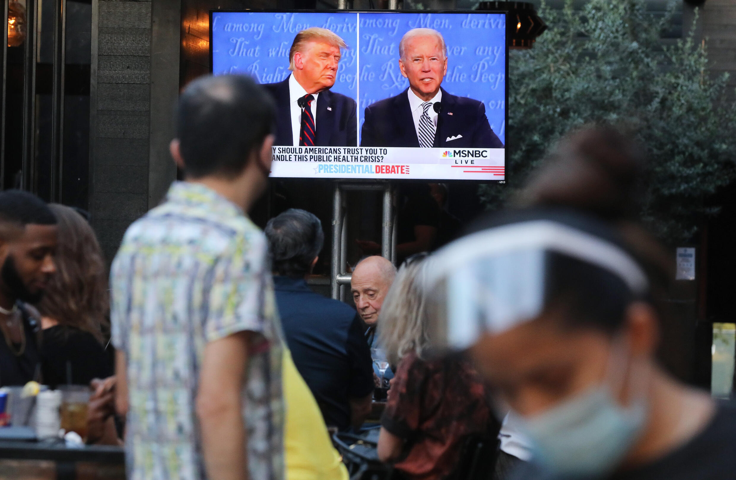 Des passants regardent la retransmission du premier débat entre l'ex-président Donald Trump et le président actuel Joe Biden lors de la campagne de 2020, à West Hollywood