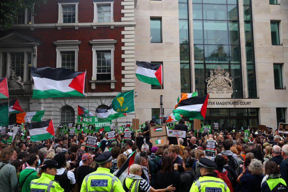 Partidarios de Liam O'Hanna, miembro de Kneecap y también conocido como Liam Og O hAnnaidh, quien actúa bajo el nombre de Mo Chara y ha sido acusado de un delito de terrorismo en relación con la supuesta exhibición de una bandera de Hezbolá en el escenario en 2024, ondean banderas palestinas mientras se reúnen frente al Tribunal de Magistrados de Westminster, en Londres, Gran Bretaña, el 20 de agosto de 2025.