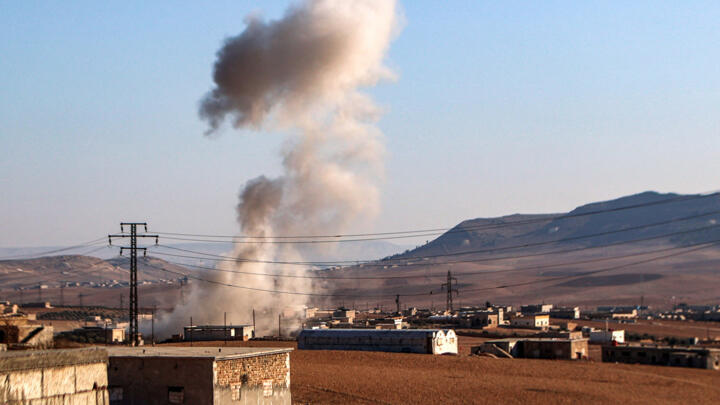 A plume of smoke erupts from bombardment amidst ongoing battles between the Turkish-backed Syrian National Army faction and the Kurdish-led Syrian Democratic Forces (SDF) at a position near the Tishri