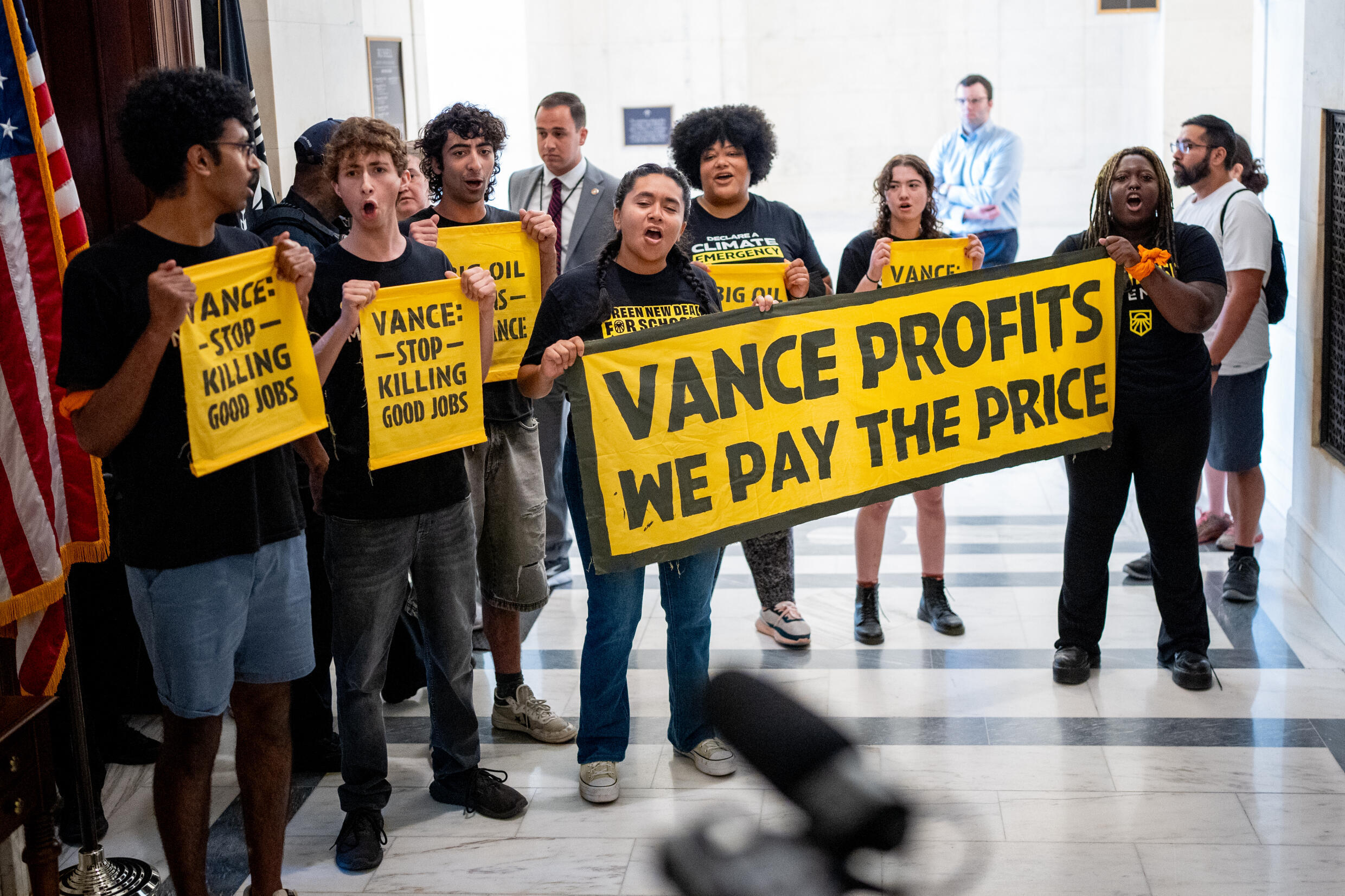 Des militants écologistes brandissent une pancarte "Vance profite, on en paye le prix" accusant le colistier de Donald Trump, J.D. Vance de toucher de l'argent de l'industrie pétrolière, le 29 juillet 2024 à Washington