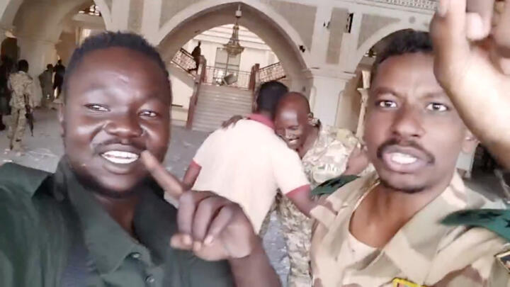 Sudanese soldiers film themselves inside the presidential palace in Khartoum after taking control of the building on March 21, 2025.