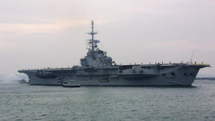 The Sao Paulo aircraft carrier (former French Foch) hidden behind navy buildings quits the military port of Brest, on February 1st, 2001.